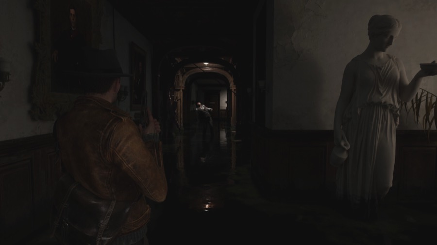 A dark flooded mansion corridor with a marble statue and a distant enemy wading through the water